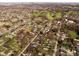 Expansive aerial view of a quiet residential neighborhood with a lush green golf course in the distance at 3039 Alice Ave, Indianapolis, IN 46237