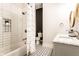 Stylish bathroom featuring a double sink vanity, patterned tile floor, and a tiled shower-tub with a decorative shower curtain at 3732 N Kenwood Ave, Indianapolis, IN 46208