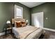 Bedroom with a bed, neutral carpet, green walls and white trim at 3732 N Kenwood Ave, Indianapolis, IN 46208