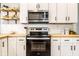 Close-up of the stove, microwave, white shaker cabinets, and butcher block countertops in the kitchen at 3732 N Kenwood Ave, Indianapolis, IN 46208