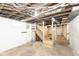 Unfinished basement with exposed ceiling and wooden stairs at 415 Ruskin Pl, Indianapolis, IN 46205