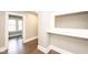 Hallway with wood floors and a built-in shelving area, leading to a room with bright windows at 415 Ruskin Pl, Indianapolis, IN 46205