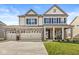Charming two-story home featuring a brick and siding facade, a three-car garage, and a welcoming front porch at 4179 Ironclad Dr, Bargersville, IN 46106