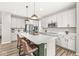 Modern kitchen featuring an island with seating, white cabinets, quartz countertops, and stainless steel appliances at 4179 Ironclad Dr, Bargersville, IN 46106