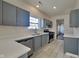 Modern kitchen with gray cabinets, stainless steel appliances, and a bright window over the sink at 5467 Powder River Ct, Indianapolis, IN 46221
