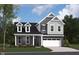 Charming two-story home showcasing a mix of stone and siding, complemented by dormer windows and a two-car garage at 5715 Cloister Ln, McCordsville, IN 46055