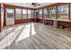 Charming sun room with many windows, natural light, and wood paneled walls and plank flooring at 5901 Crystal Bay West Dr, Plainfield, IN 46168