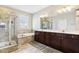 A well-lit bathroom features a glass shower, soaking tub, and double sink vanity at 5944 Aldridge Dr, Whitestown, IN 46075