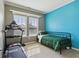 Bedroom with blue accent wall, twin bed, treadmill, and natural light at 5944 Aldridge Dr, Whitestown, IN 46075