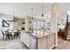 Open-concept kitchen with a large island, stainless steel dishwasher, and modern lighting flowing into the living space at 5944 Aldridge Dr, Whitestown, IN 46075
