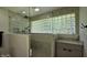 Updated shower with a glass surround, glass brick window feature and tile flooring at 6040 W Thompson Rd, Indianapolis, IN 46221