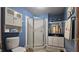 Well-lit bathroom featuring blue walls, tile floor, and a glass-enclosed shower at 6040 W Thompson Rd, Indianapolis, IN 46221