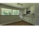Versatile bonus room with storage cabinets, a window view, and hardwood floors at 6040 W Thompson Rd, Indianapolis, IN 46221