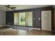 Bright living room with hardwood floors, large windows, and staircase access to the basement at 6040 W Thompson Rd, Indianapolis, IN 46221