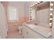 A bathroom with pink tile, a white vanity, and a lighted mirror at 616 Gibbs Ct, Plainfield, IN 46168