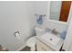 A half bath with a white toilet and vanity, gray walls and dark vinyl floors at 616 Gibbs Ct, Plainfield, IN 46168