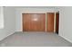 A neutral bedroom with gray carpet, closet, and an open door to another room at 616 Gibbs Ct, Plainfield, IN 46168