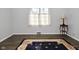 An empty bedroom with hardwood floors covered by an ornate rug and bright light from a window at 616 Gibbs Ct, Plainfield, IN 46168