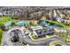 High-angle shot showcases community amenities: tennis courts, clubhouse, playground, parking area, and a scenic pond at 6571 Hunters S Rdg, Zionsville, IN 46077