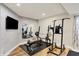 Basement workout area with mirrored wall and TV, complete with weight training equipment at 6571 Hunters S Rdg, Zionsville, IN 46077