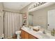 Well-lit bathroom featuring a double vanity, decorative mirrors, and a neutral shower curtain at 6571 Hunters S Rdg, Zionsville, IN 46077