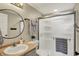 Well-lit bathroom featuring a glass-enclosed shower, vanity, and round mirror with modern fixtures at 6571 Hunters S Rdg, Zionsville, IN 46077