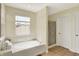 Bathroom with a soaking tub below a bright window and a glass door shower at 6571 Hunters S Rdg, Zionsville, IN 46077