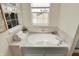 Bright bathroom with a soaking tub, white tile, and natural light at 6571 Hunters S Rdg, Zionsville, IN 46077