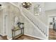 Elegant foyer with a staircase, chandelier, and decorative wallpaper, flowing into hardwood floors at 6571 Hunters S Rdg, Zionsville, IN 46077