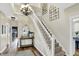Elegant foyer with a staircase, chandelier, and decorative wallpaper, flowing into hardwood floors at 6571 Hunters S Rdg, Zionsville, IN 46077