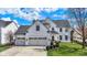 Charming two-story home featuring a three-car garage, manicured lawn, and classic white siding at 6571 Hunters S Rdg, Zionsville, IN 46077