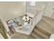 Elegant foyer with a chandelier, white railings, and staircase leading to a view of the inviting living room at 6571 Hunters S Rdg, Zionsville, IN 46077