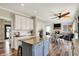 Open concept kitchen features a blue island, stainless appliances, breakfast nook and view into the living room at 6571 Hunters S Rdg, Zionsville, IN 46077
