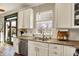This well-lit kitchen offers stainless appliances, white cabinets, granite counters, and modern fixtures at 6571 Hunters S Rdg, Zionsville, IN 46077