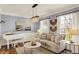 Comfortable living room with hardwood floors, neutral tones, piano, sofa, and ample natural light at 6571 Hunters S Rdg, Zionsville, IN 46077