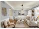 Comfortable living room with hardwood floors, neutral tones, piano, sofa, and ample natural light at 6571 Hunters S Rdg, Zionsville, IN 46077