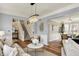 Bright living room with hardwood floors, neutral tones, elegant lighting, and seamless flow into dining at 6571 Hunters S Rdg, Zionsville, IN 46077