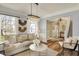 Bright living room with hardwood floors, neutral tones, elegant lighting, and seamless flow into entryway at 6571 Hunters S Rdg, Zionsville, IN 46077