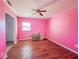 Bright pink bedroom with ceiling fan and wood floors provides a cozy space at 6616 W Thompson Rd, Indianapolis, IN 46241