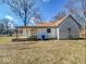 Angle shot of a one-story house with white siding, a covered porch, and a well-lit view of the side yard at 6616 W Thompson Rd, Indianapolis, IN 46241