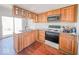 Kitchen boasts wood cabinets, stainless steel appliances, and opens to the backyard at 6616 W Thompson Rd, Indianapolis, IN 46241