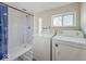 Bright laundry room features modern appliances and a walk-in shower with a sleek design and natural light at 6616 W Thompson Rd, Indianapolis, IN 46241