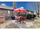 This outdoor patio features a table and 4 chairs with an orange umbrella, and a black grill at 7152 Sandalwood Dr, Avon, IN 46123