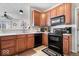 Efficient kitchen featuring wood cabinetry, black appliances, and neutral countertops at 7236 Wyatt Ln, Indianapolis, IN 46217