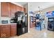 Open concept kitchen with stainless steel refrigerator and adjoining game room at 7236 Wyatt Ln, Indianapolis, IN 46217