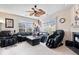 Bright living room featuring a ceiling fan, large windows, and a comfortable leather couch at 7236 Wyatt Ln, Indianapolis, IN 46217