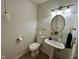 Small bathroom features a pedestal sink, toilet, and stylish light fixture at 7902 Benjamin Dr, Lawrence, IN 46226