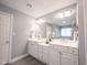 Bright and modern bathroom with dual sinks, granite countertops, and a large mirror at 9921 N Wind River Run, McCordsville, IN 46055