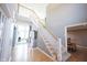 Bright foyer featuring a staircase with white railings and wood floors, leading to the upper level at 9921 N Wind River Run, McCordsville, IN 46055
