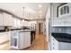 Bright kitchen with stainless appliances, white cabinetry, granite counters, and spacious island with seating at 9921 N Wind River Run, McCordsville, IN 46055